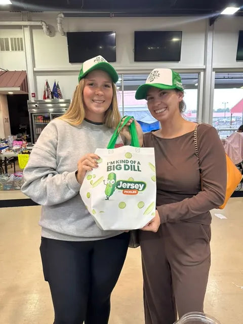 Two customers in Big Dill hats holding a Jersey Pickles tote